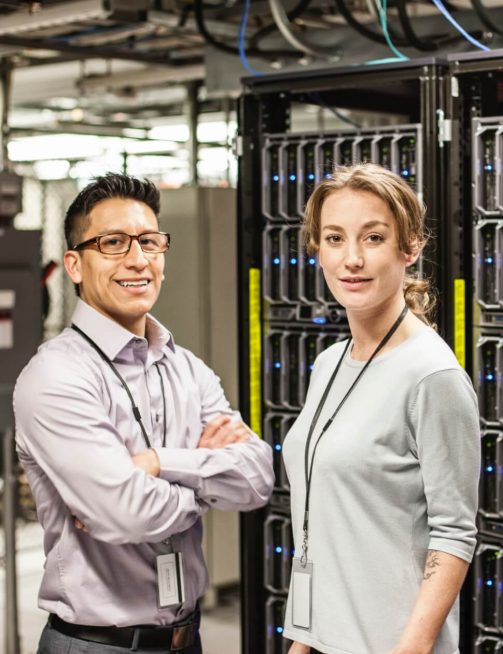 Two Team Members Standing Shoulder to Shoulder in front of a Server