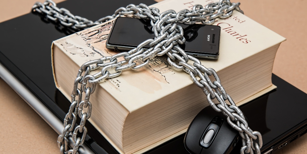 laptop book and phone with chain and padlock